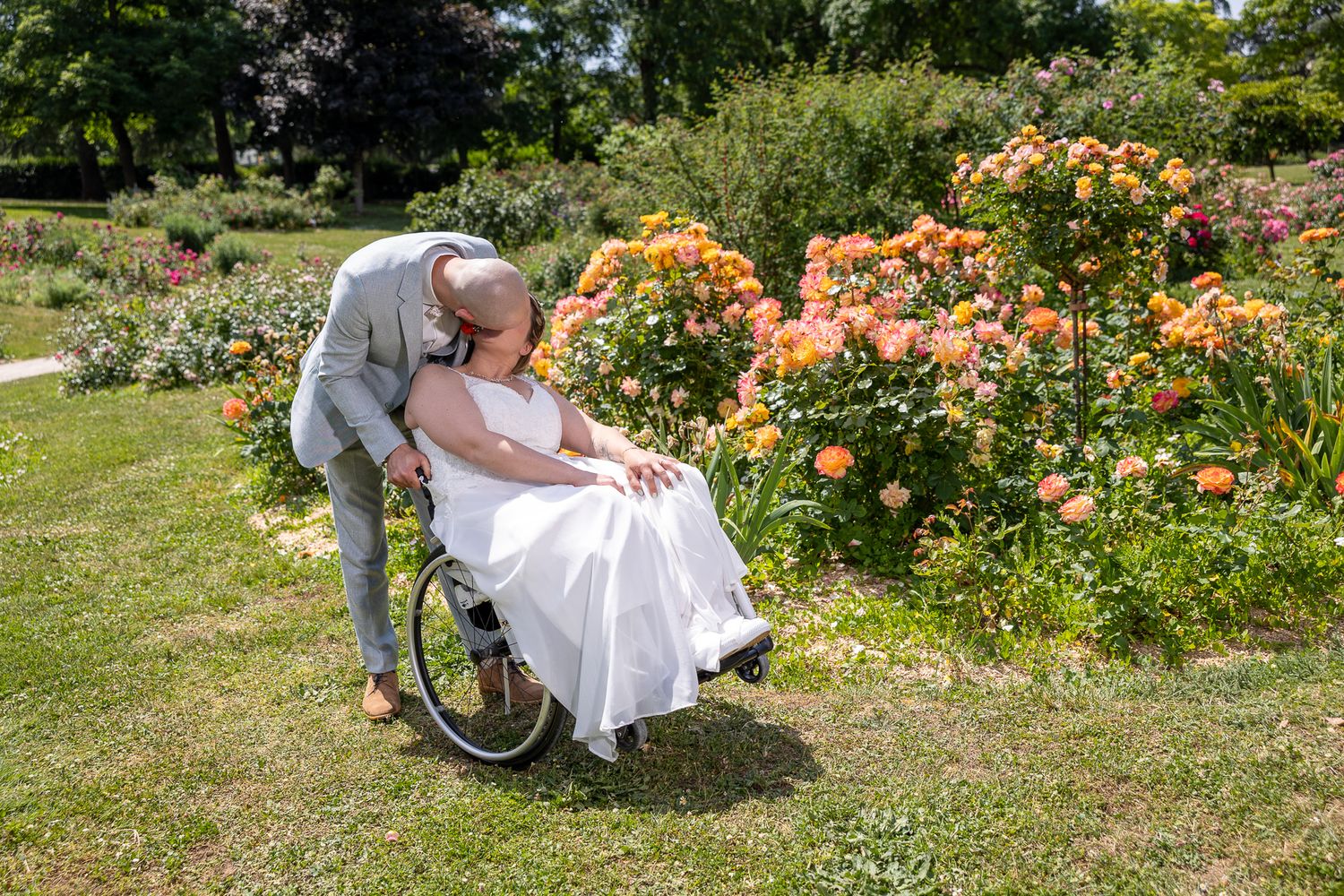 A tender moment captured in a blooming garden with peach roses in the background.