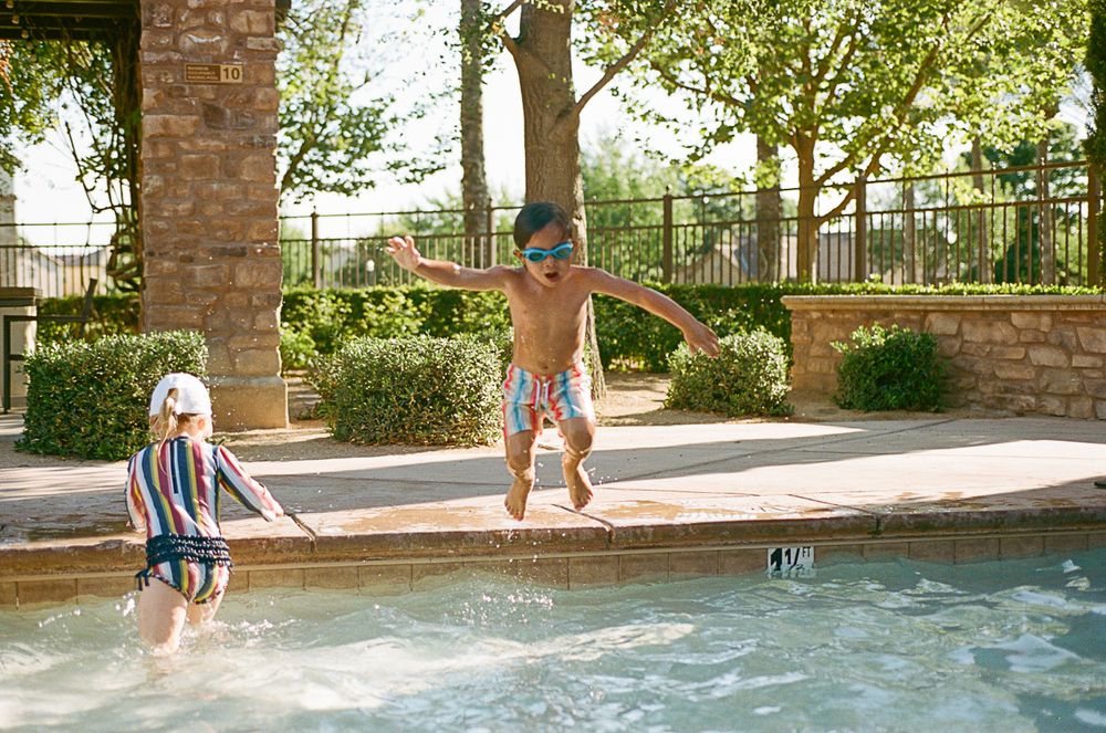 Playful pool scene with swimmers enjoying a sunny afternoon splash.
