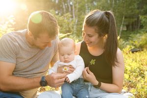 Family enjoying a tender moment together in a sunlit garden setting with warm golden lighting.