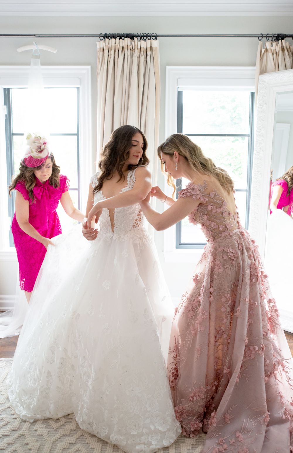 Wedding dress preparation moment with floral pink gown detail.