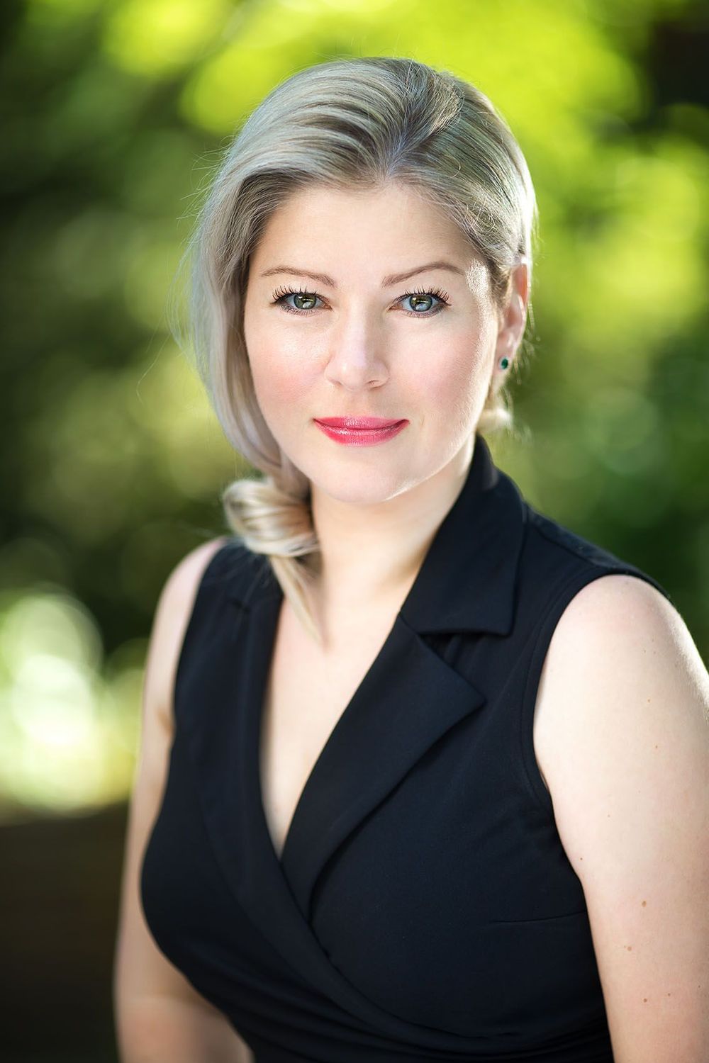 Female CEO professional branding headshot outdoors with soft green background, Atlanta personal branding photography.