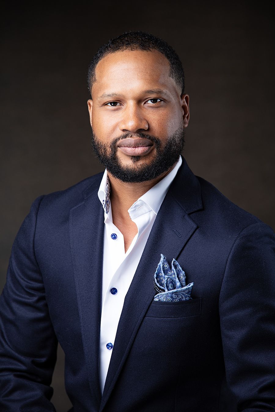 Corporate headshot of male entrepreneur in navy suit with pocket square, dramatic studio lighting in Atlanta.