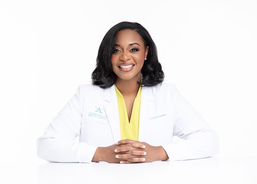 Confident business owner smiling in white coat against bright background, Atlanta LinkedIn headshot photography.