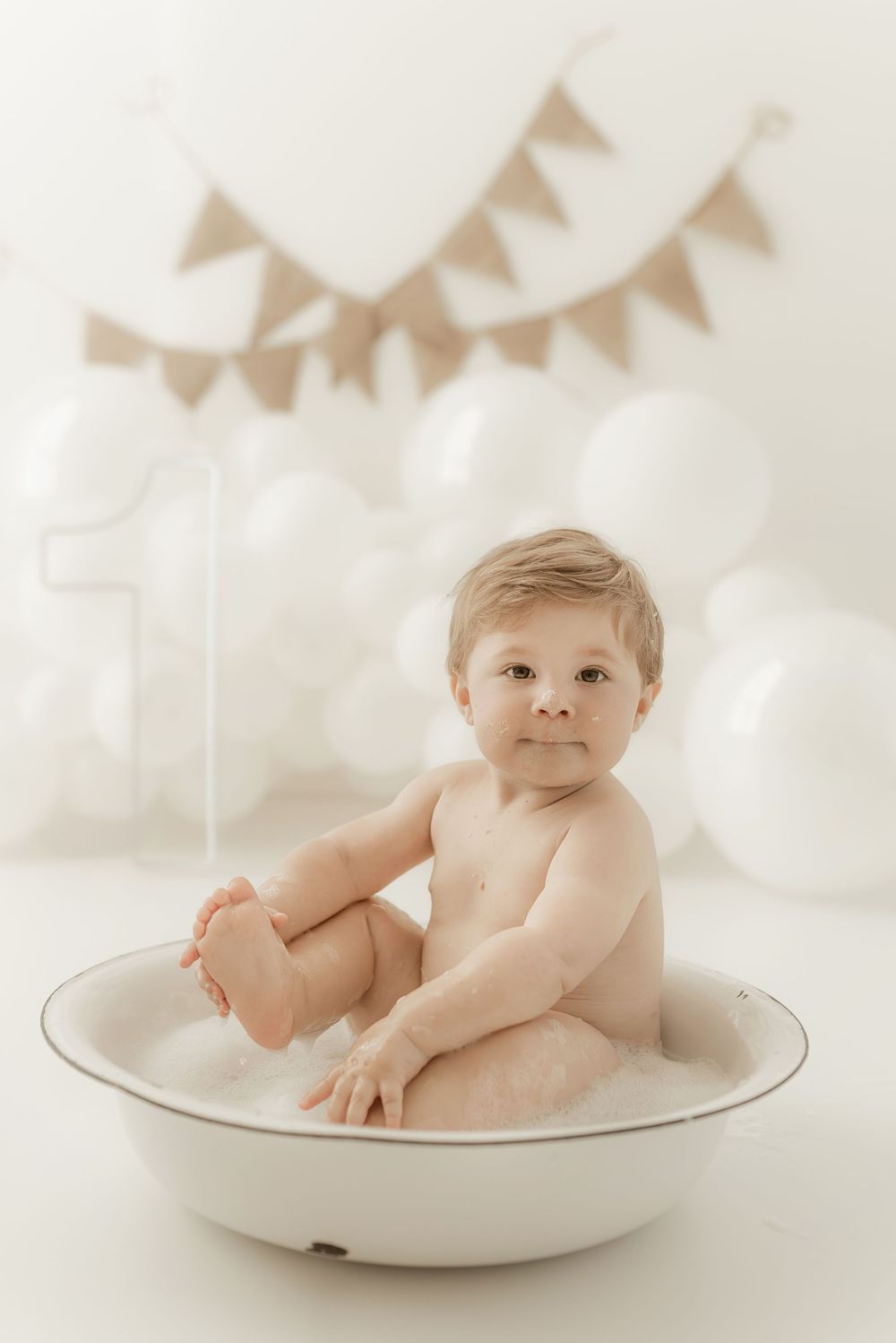 Baby photography series showing multiple poses of an infant sitting in a white ceramic bowl with banner decorations.
