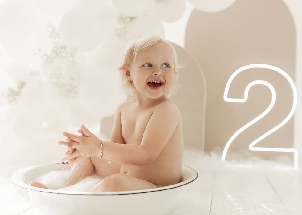 A collection of sweet baby bath time photos showing an infant enjoying splashing and playing in soapy water.