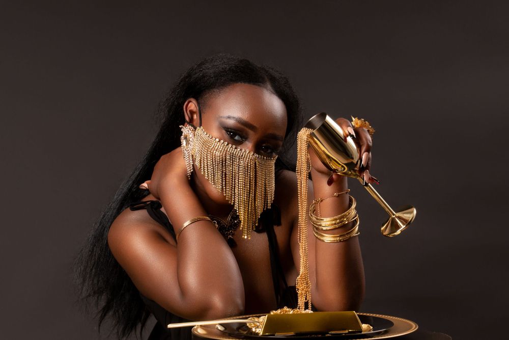 Luxurious dining portrait featuring gold accessories and dramatic makeup with fringe details.