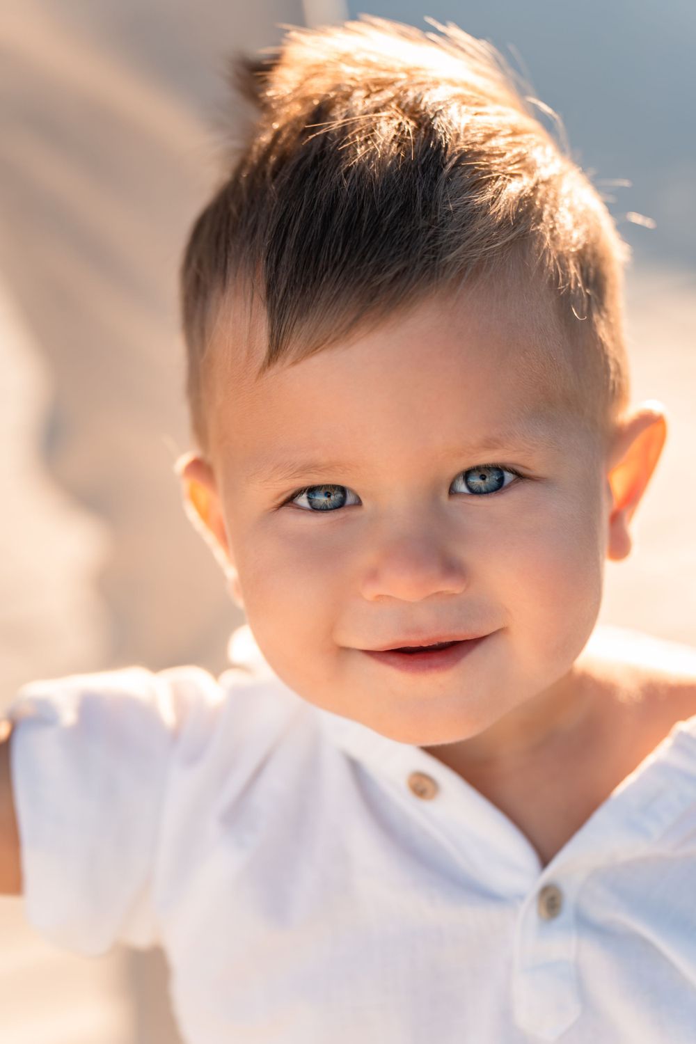 little boy smiling for photo with golden light behind him