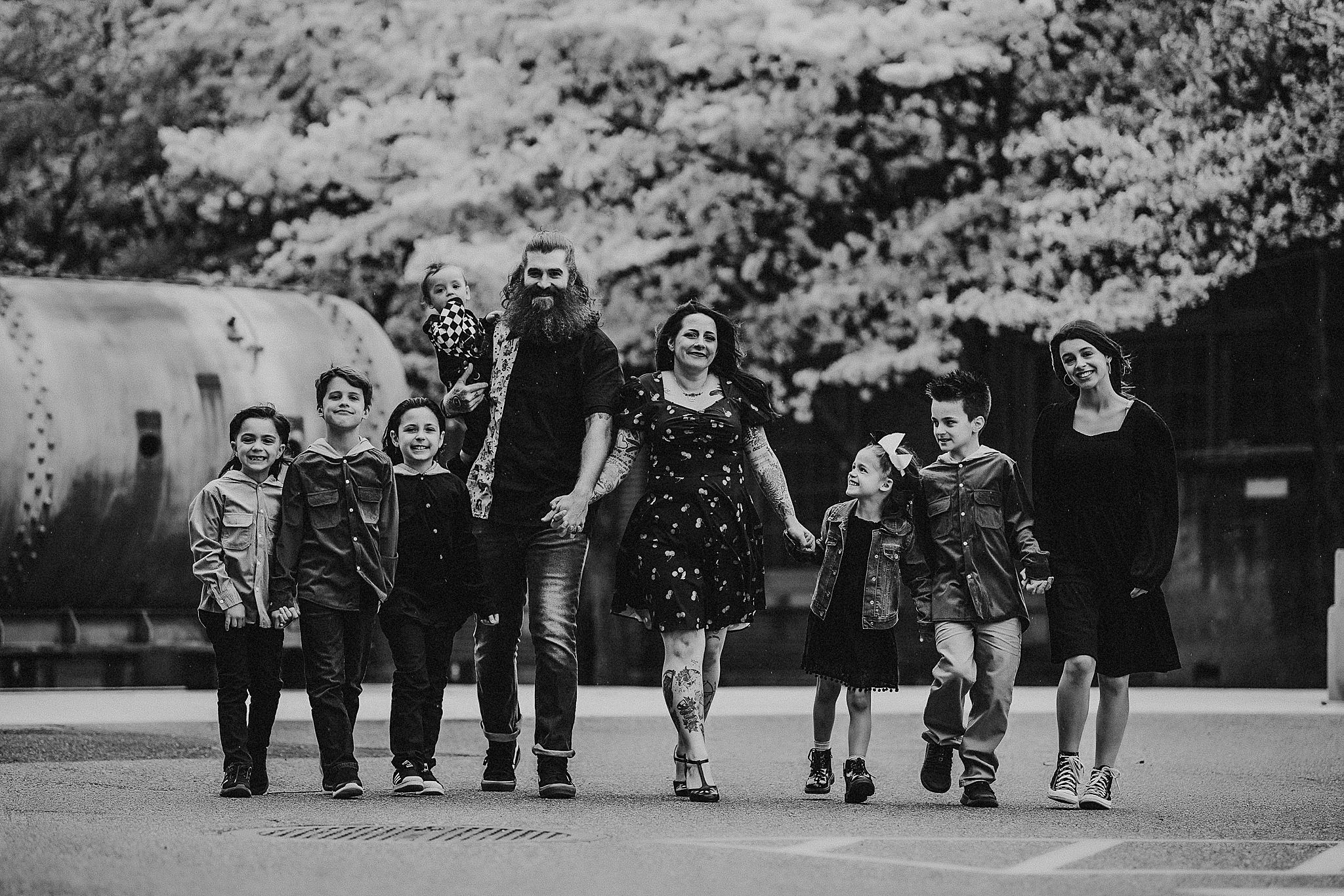 Black and white photo of a group walking and laughing together along a path outdoors.