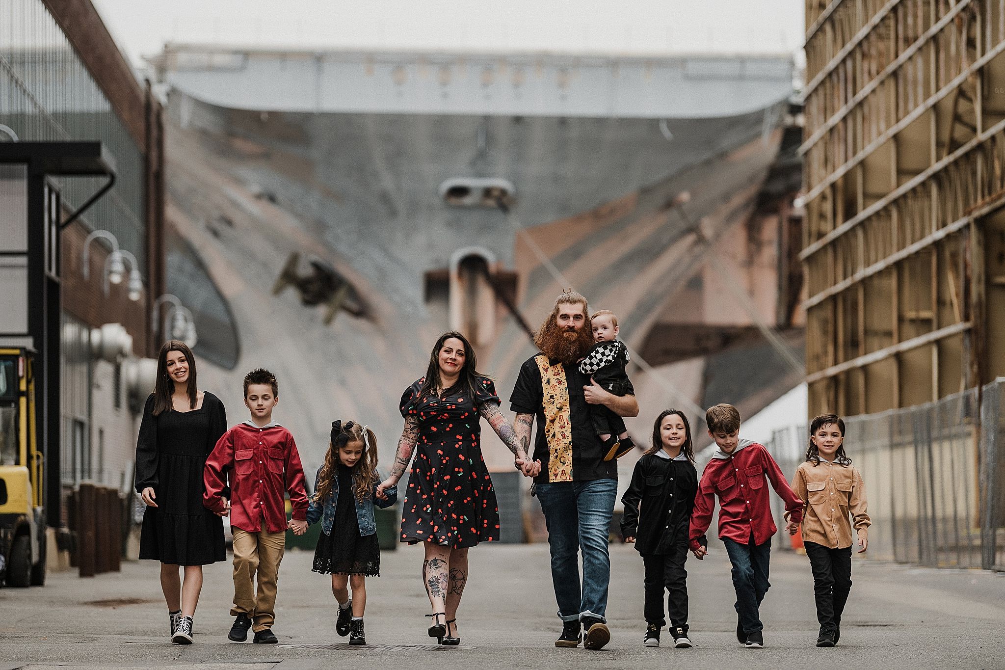 Group walking in formation through an industrial corridor with dramatic architectural backdrop.