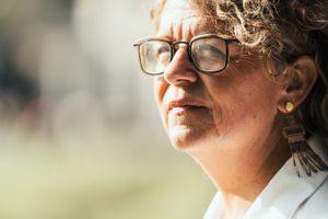 a beautiful portrait photo of a beautiful elderly lady in a park loving herself