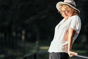 a beautiful portrait photo of a beautiful elderly lady in a park loving herself