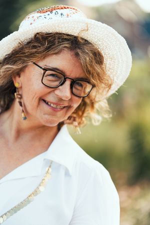 a beautiful portrait photo of a beautiful elderly lady in a park loving herself