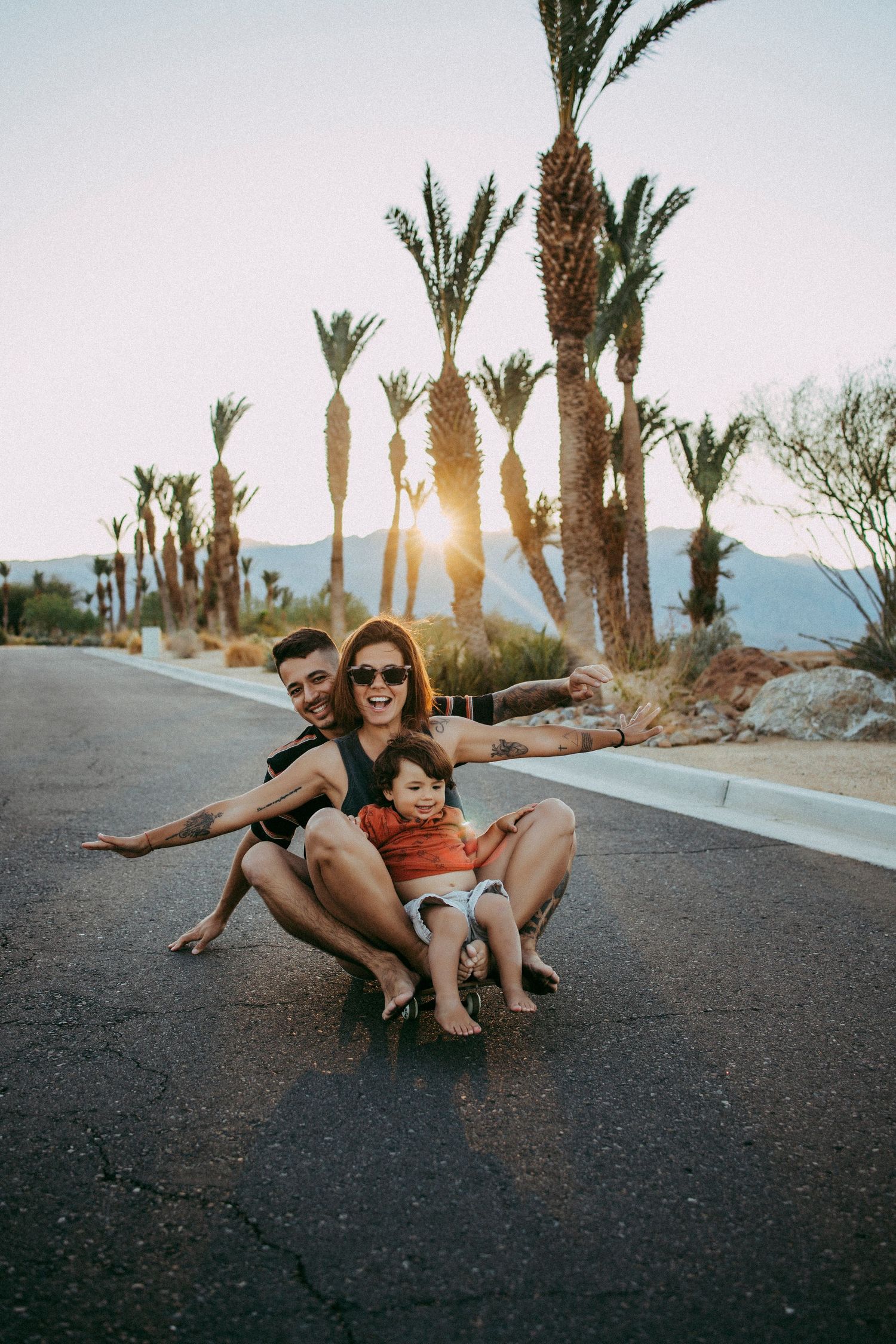 A playful moment on a palm tree-lined street at sunset in a desert setting.