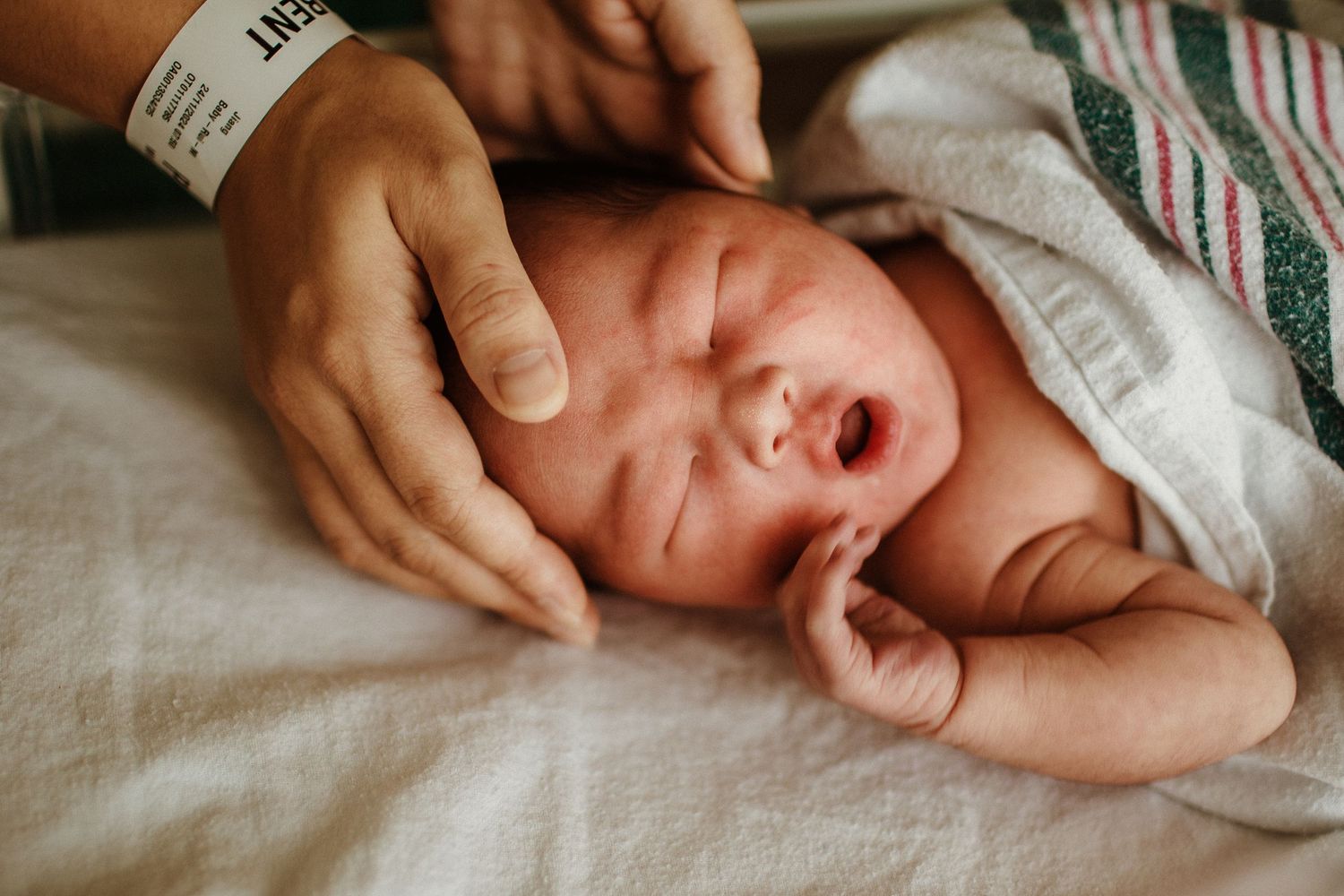 Close-up series of a crying newborn baby with adult hands providing comfort and care.