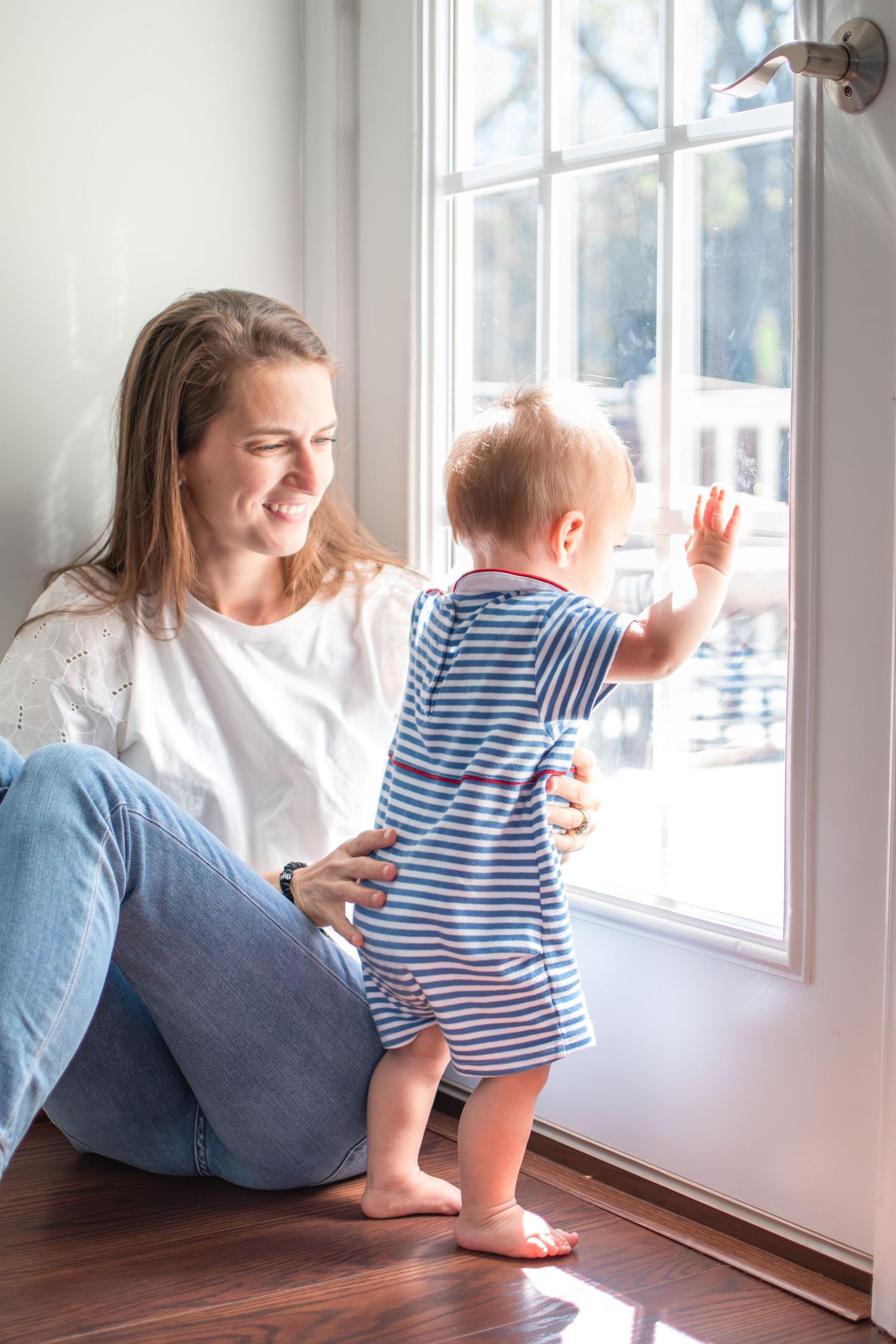A mom and her little boy look out the back window together in their Ardmore home.