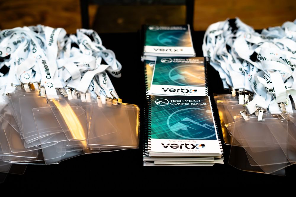 Stack of Vertx branded notebooks with conference materials and shredded paper.