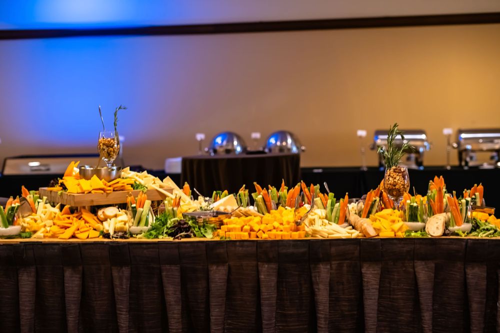Elegant buffet spread with colorful appetizers and decorative arrangements on a dark tablecloth.