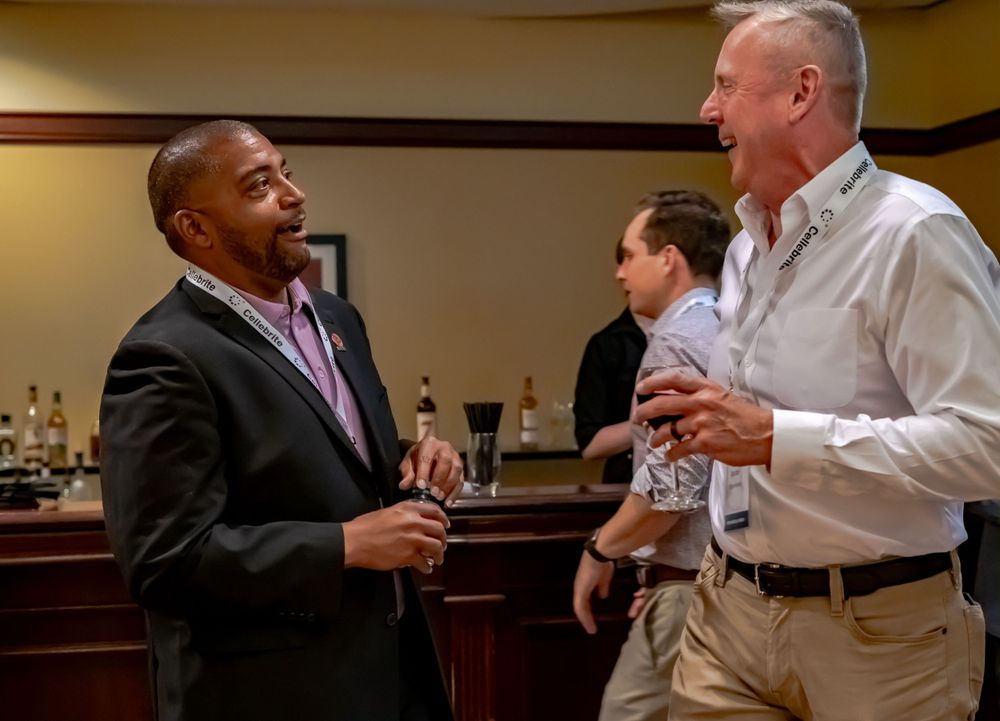 Business professionals engaged in conversation during an indoor networking event.
