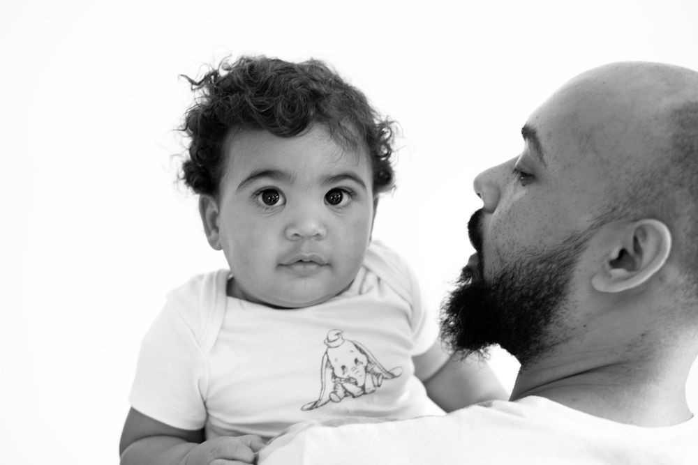 Black and white candid portrait showing tender parent-child interaction.