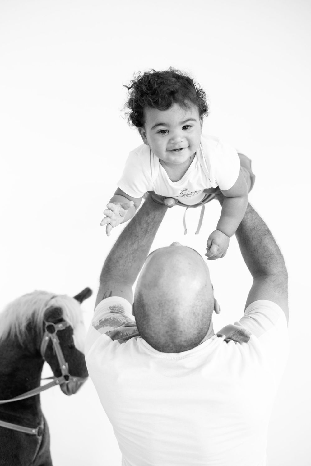 Black and white photo of playful moment between parent and child.