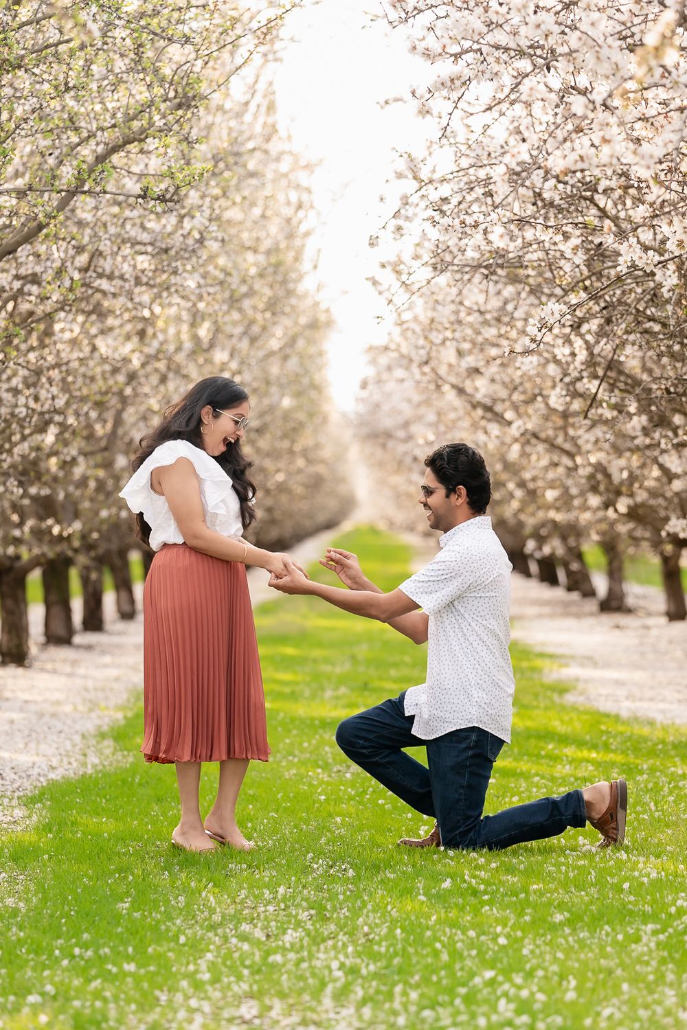 Playful couple photography in blooming almond orchards, Tracy, CA. Soft and intimate moments captured beautifully.