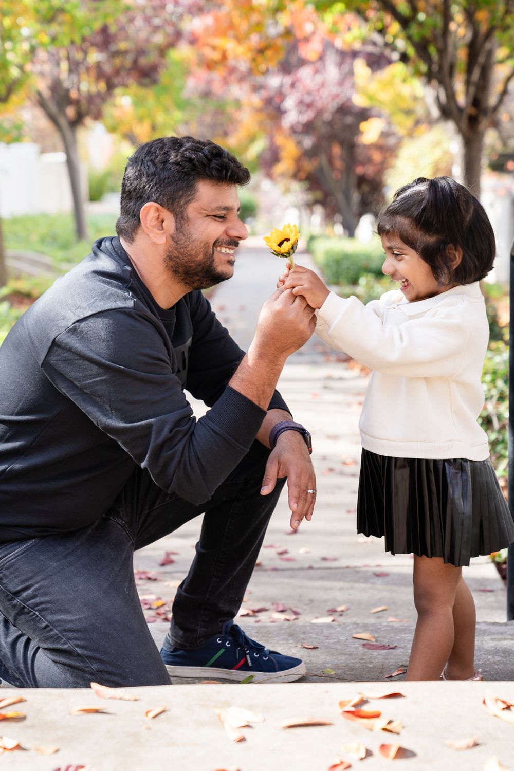 father and daughter sharing a sweet bond where girl is giving him a flower