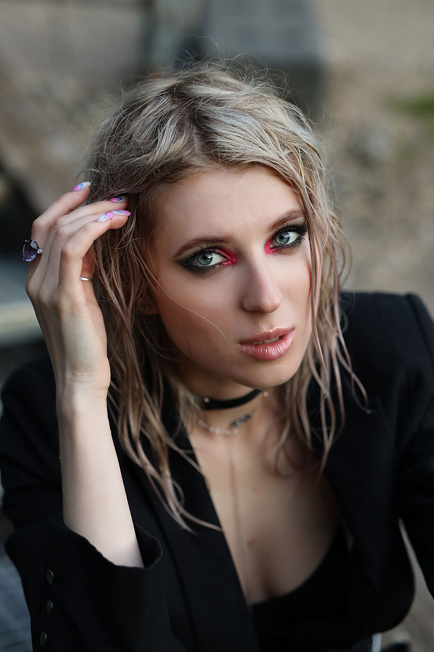 Portrait of a blonde model with smokey eye makeup with pink pigment.  The girl has wet hair