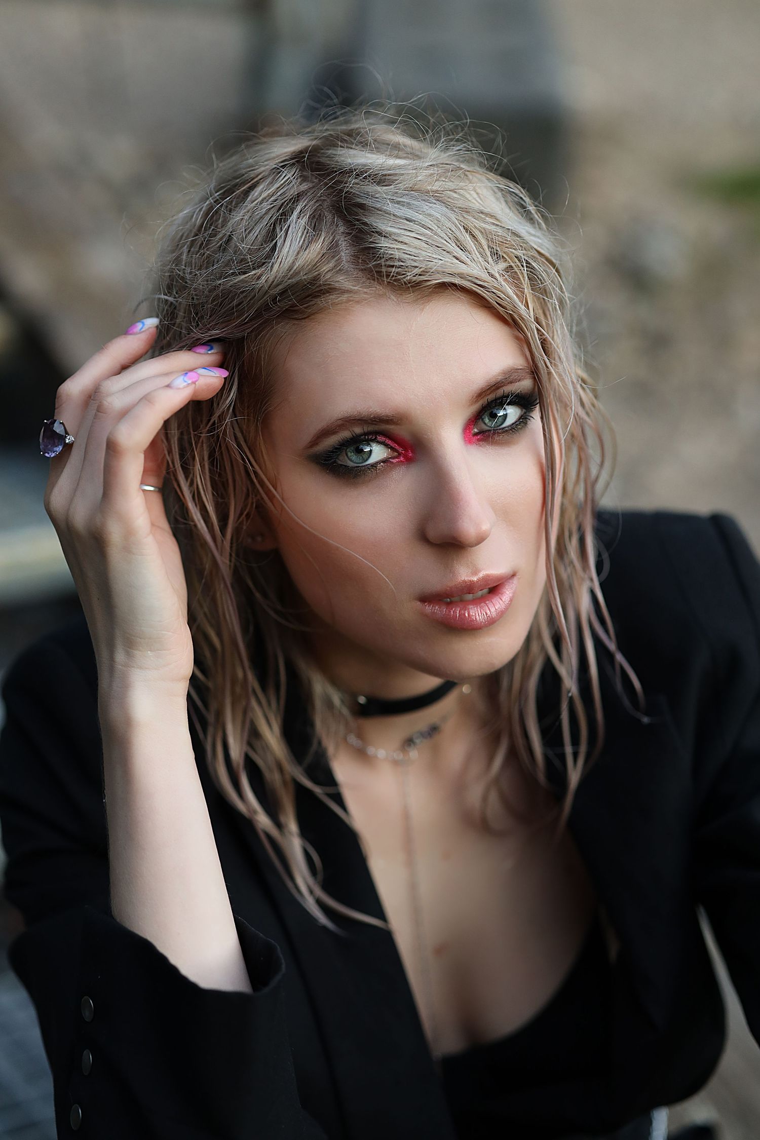 Portrait of a blonde model with smokey eye makeup with pink pigment.  The girl has wet hair