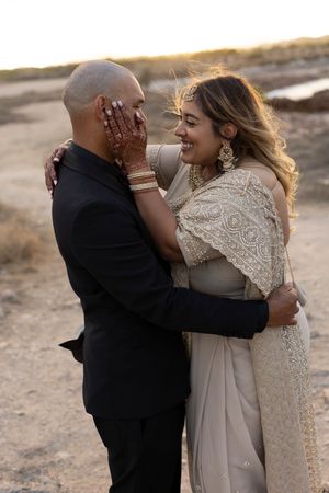 A couple embraces in a romantic moment during their outdoor photoshoot at sunset.