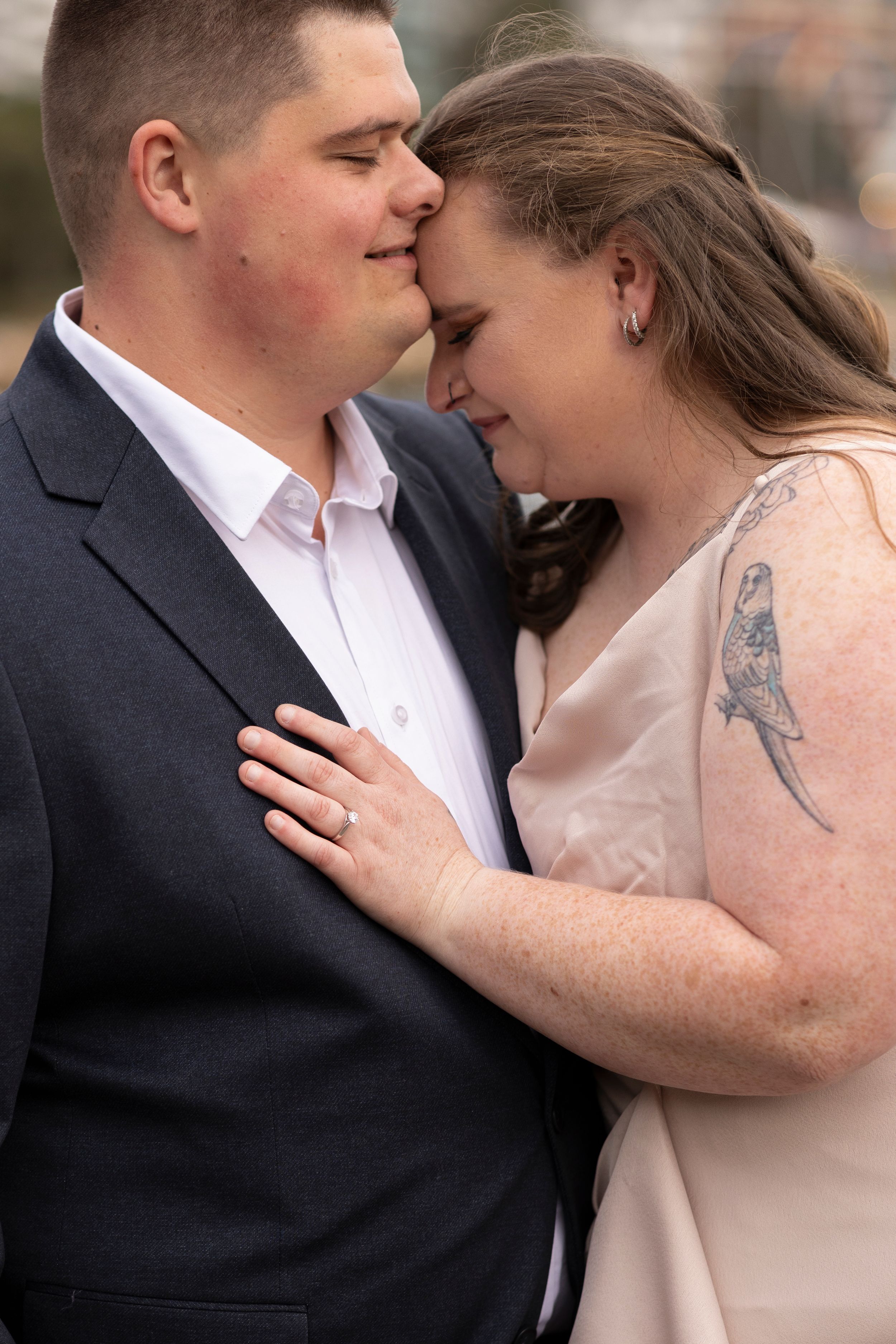 Intimate engagement photo of couple sharing tender moment.