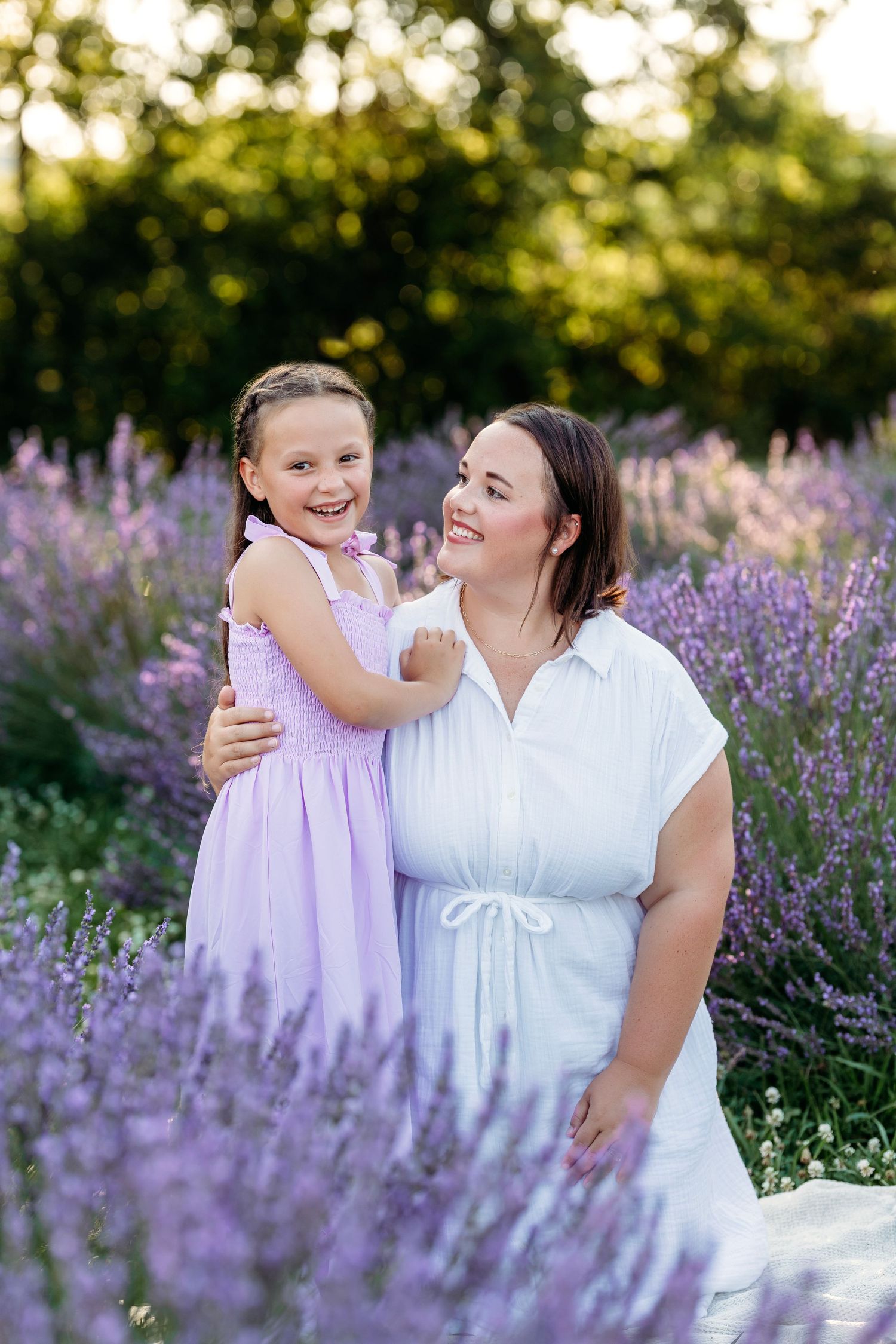 A mom and daughter share a joyful moment together in a blooming lavender field at sunset. Middle Tennessee Best Family Photographer