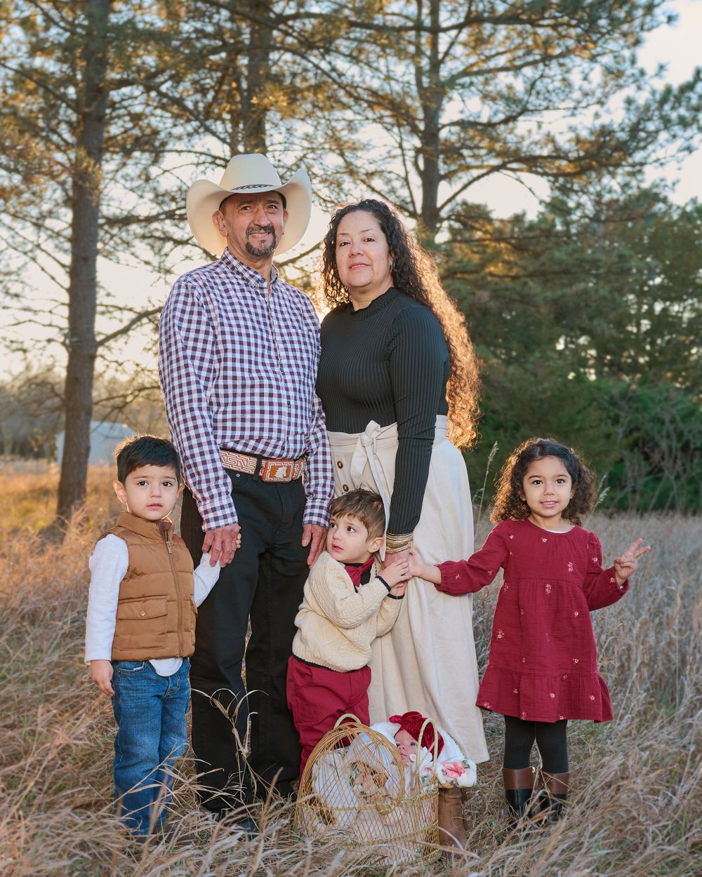 Family portrait in outdoor natural setting with fall colors and pine trees.