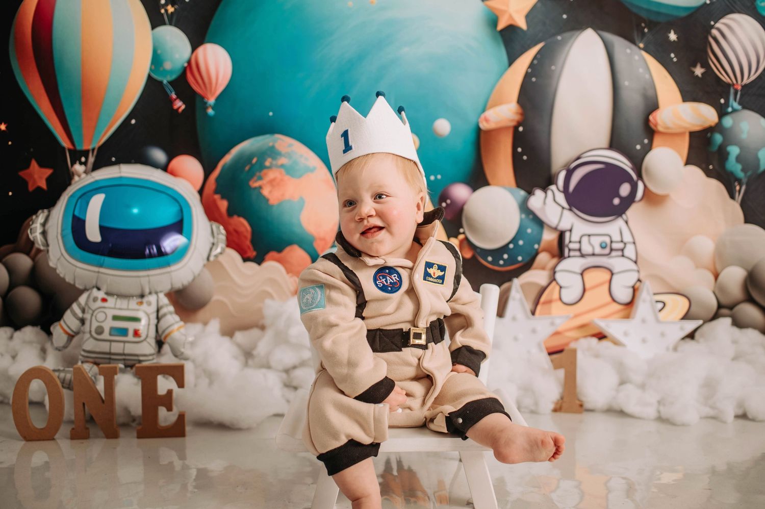 Astronaut themed birthday shoot with space decorations and hot air balloon backdrop.