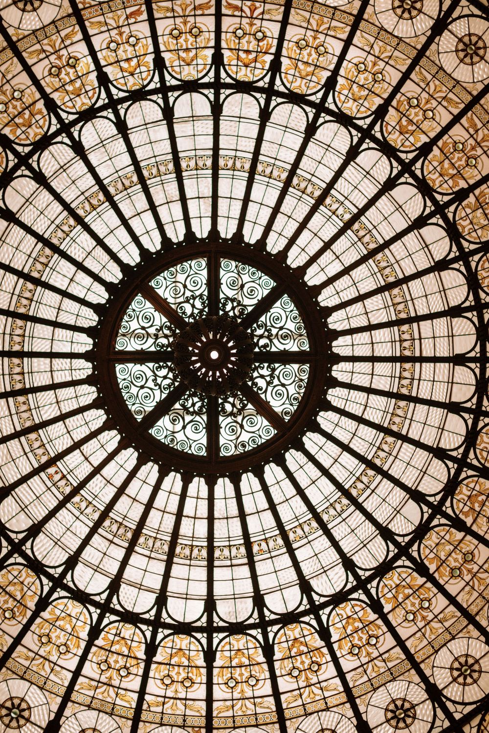 An ornate stained glass dome ceiling with intricate geometric patterns and natural light.
