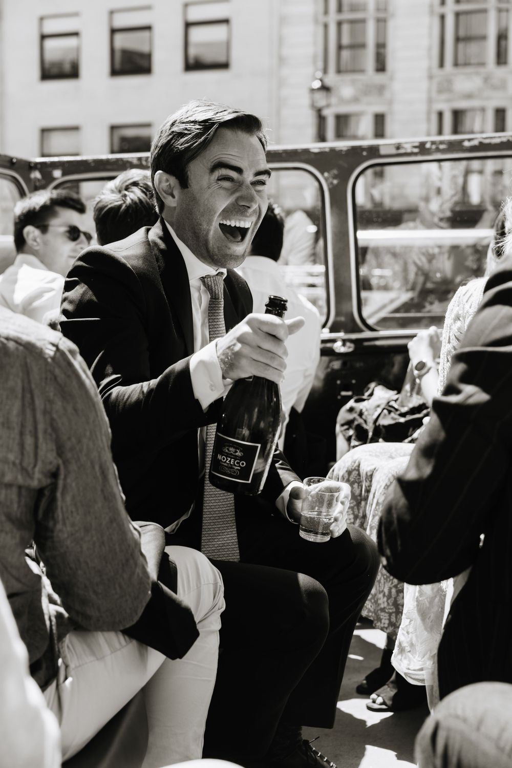 Joyful celebration with champagne at an outdoor gathering in black and white.