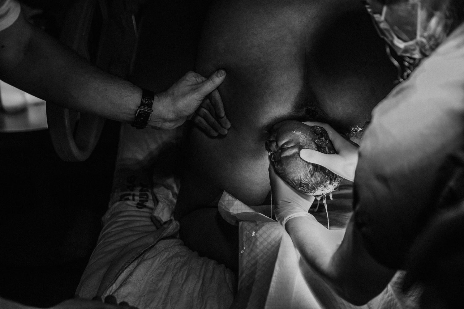 A monochrome close-up of someone getting a tattoo from a professional artist working with their equipment.