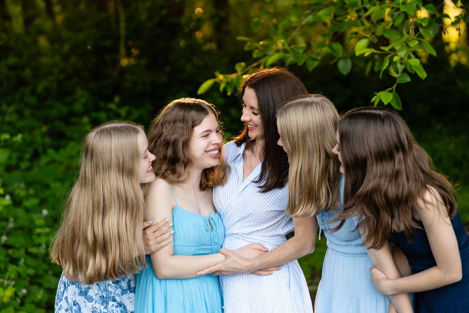 Mother smiles and looks at her daughter in a forest in Seattle.