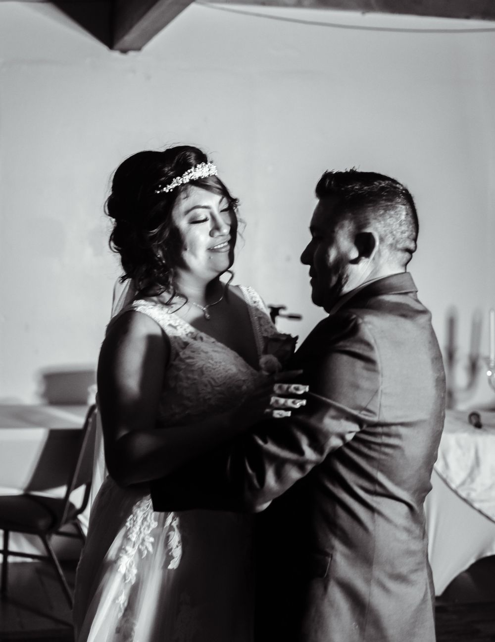 Intimate black and white portrait of couple dancing at their wedding celebration.