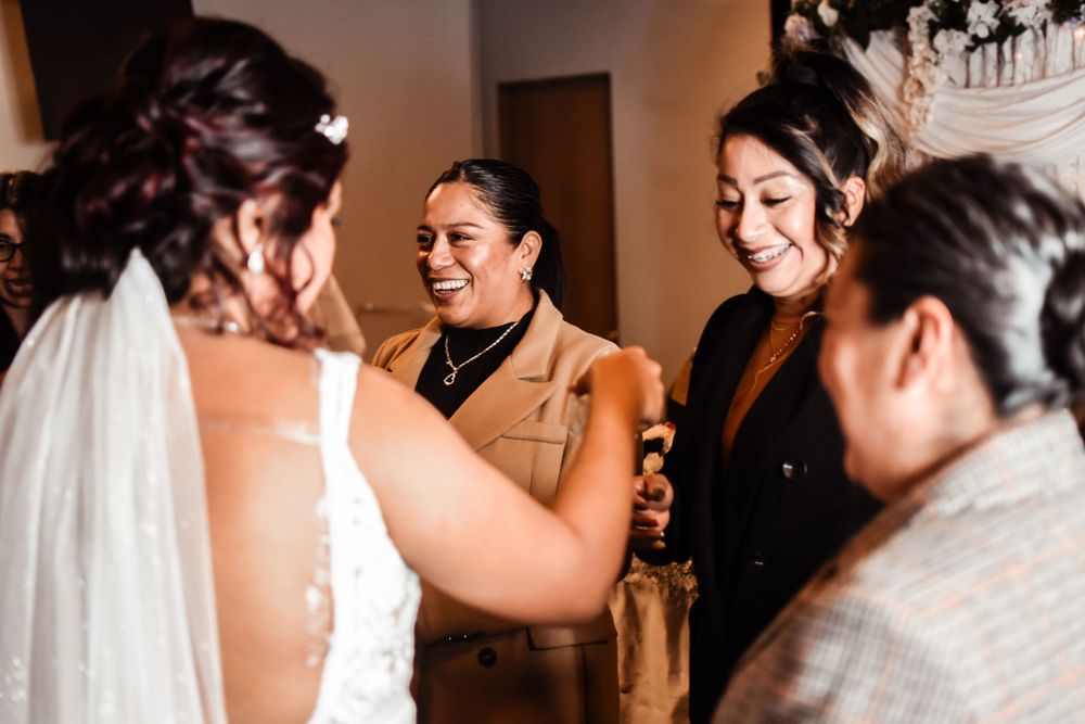 Wedding guests share cheerful moment during celebration in indoor venue.