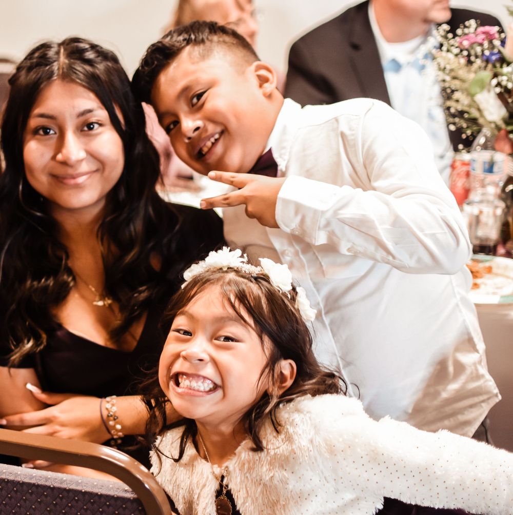 Wedding reception guests share joyful laughter while seated at dining table.