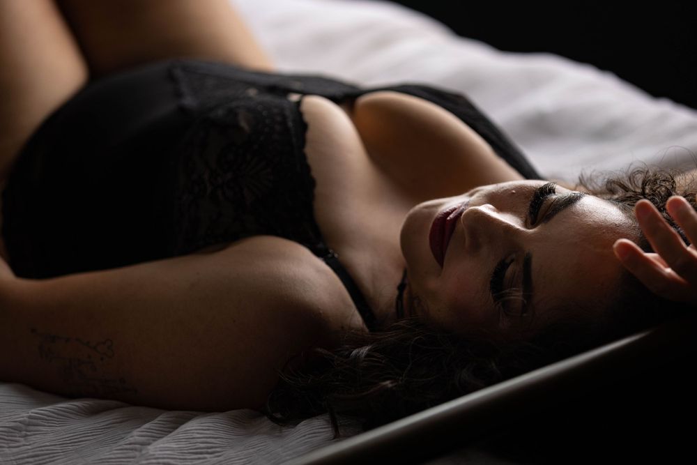 Woman lying in bed during boudoir photo shoot in Los Angeles.