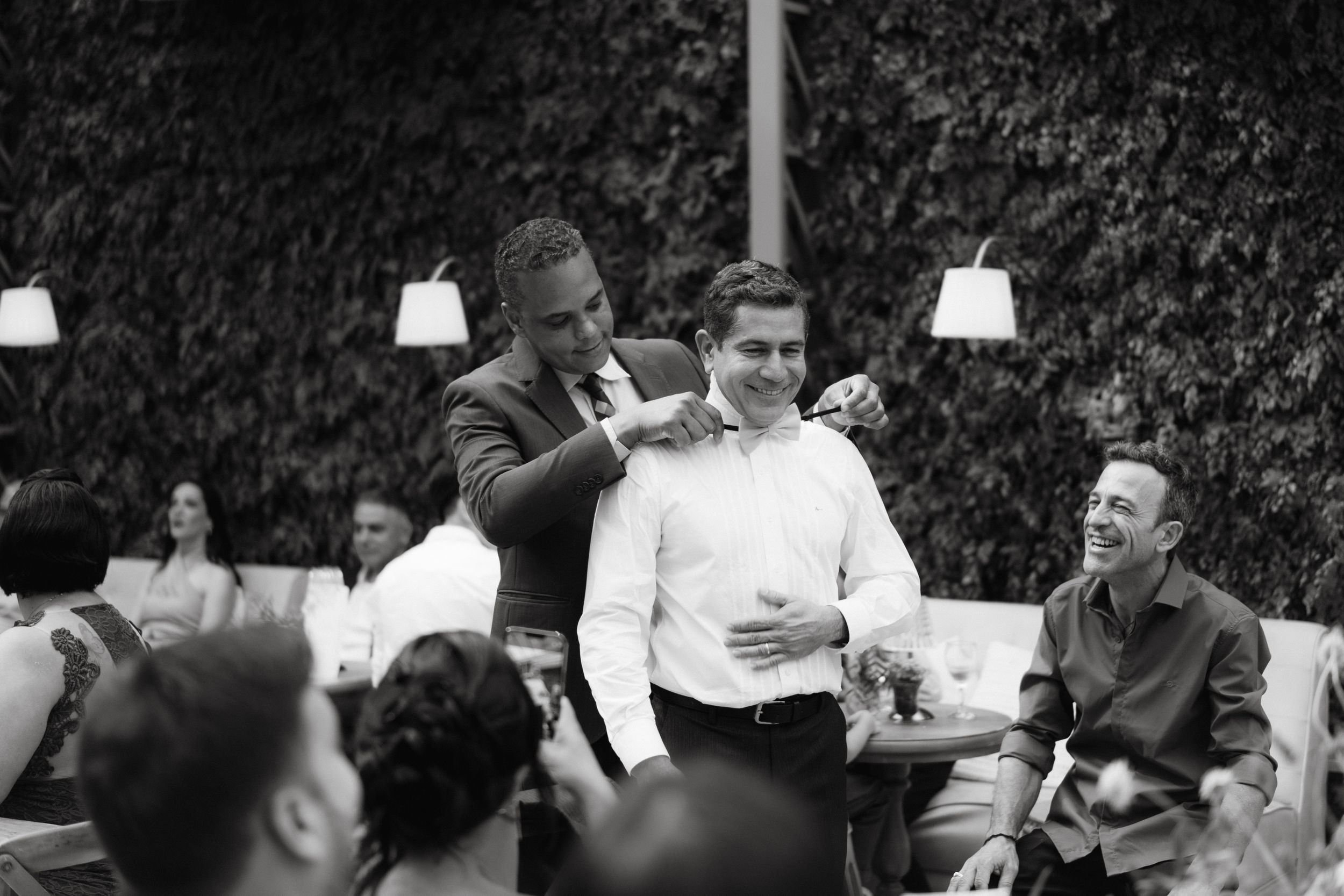 Vintage black and white photograph of wedding reception gathering outdoors.