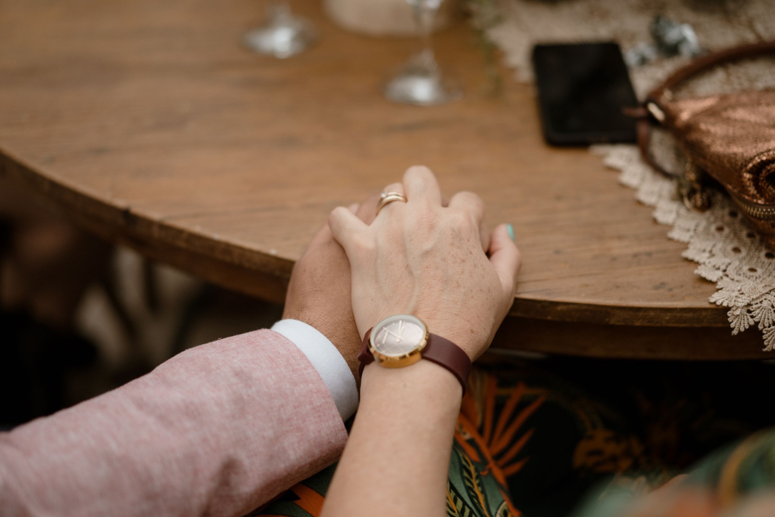 Close-up of hands during an intimate wedding ceremony ritual.