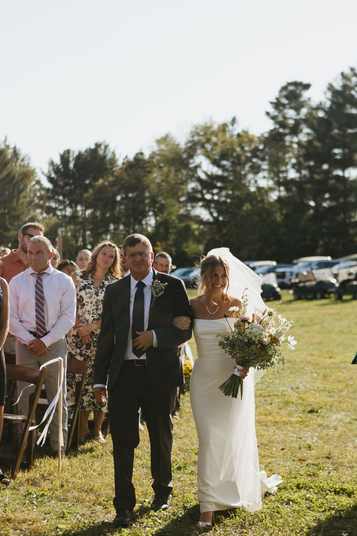 Two brides sharing a lovely moment reading their vows underneath the trees.