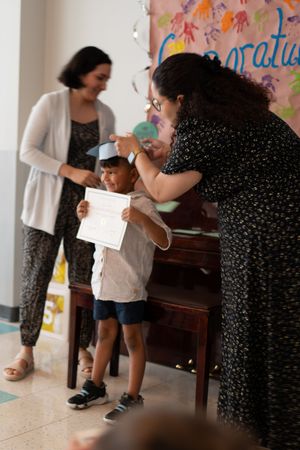 Children and adults interacting in a classroom setting with colorful wall decorations.