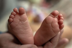 Close-up series of tiny baby feet against blurred background.