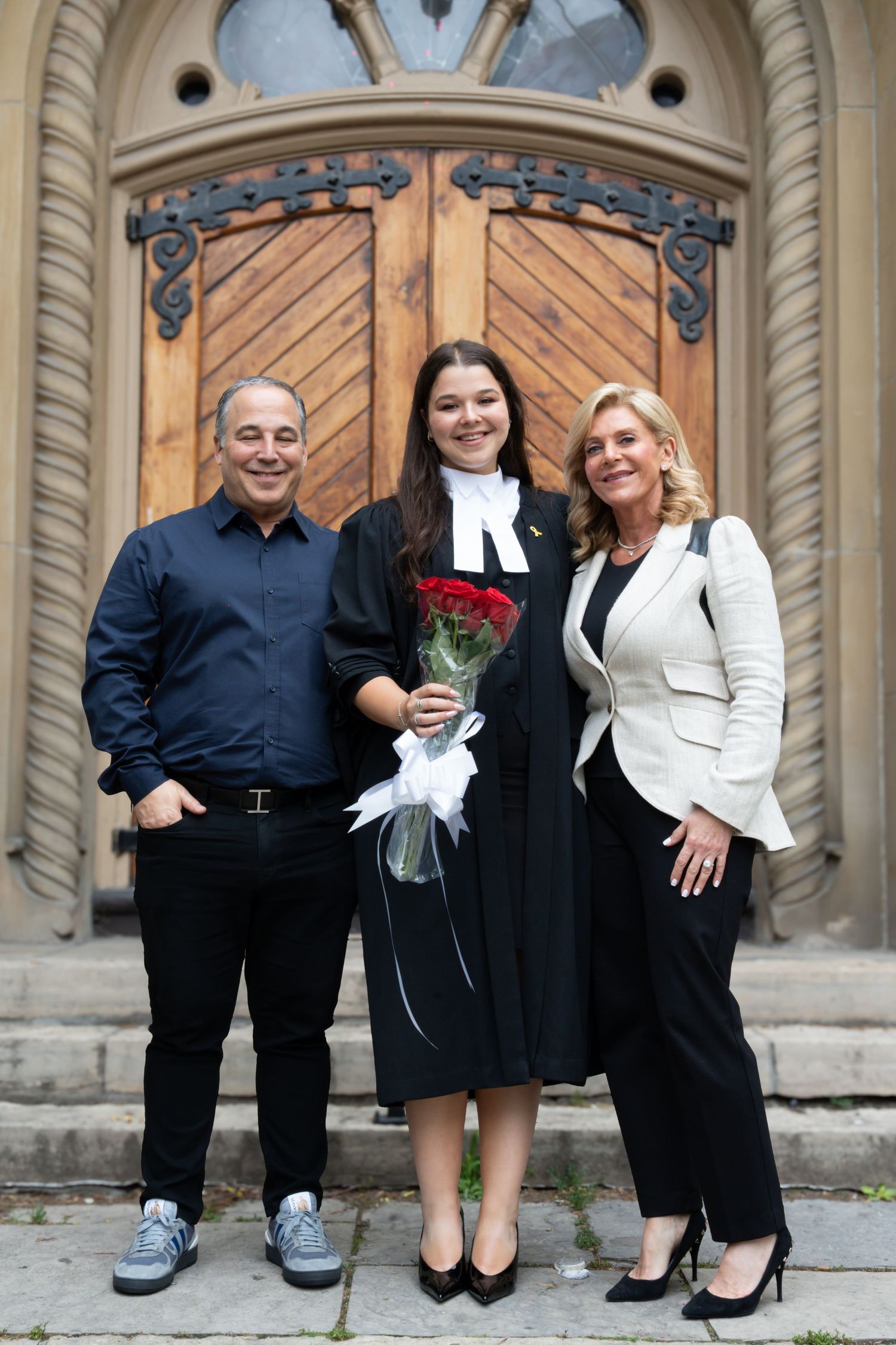 Graduation photos showing different shoes and lower legs of people in formal black and white attire near stone architecture.