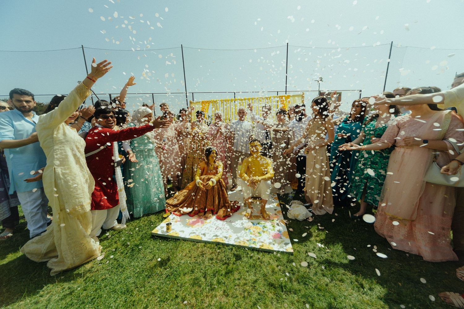 Bride and Groom with confetti over them during a pre wedding haldi ceremony