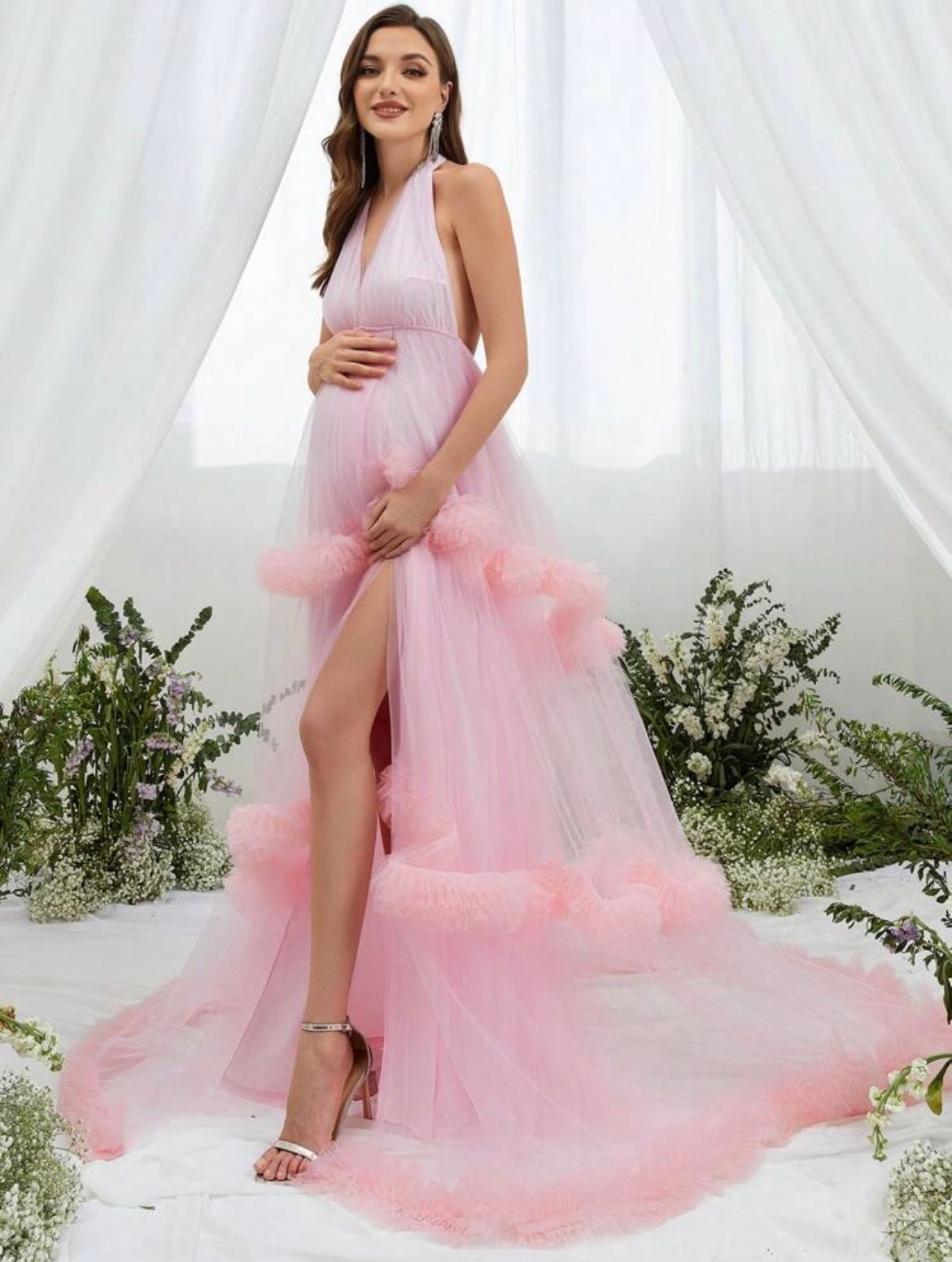 Ethereal pink tulle maternity gown photographed in a bright white studio setting.