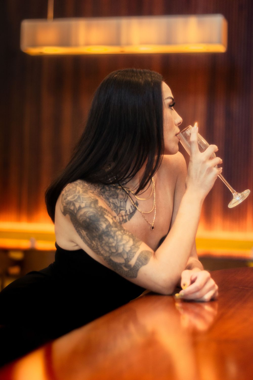 a woman at a bar taking a sip from her glass